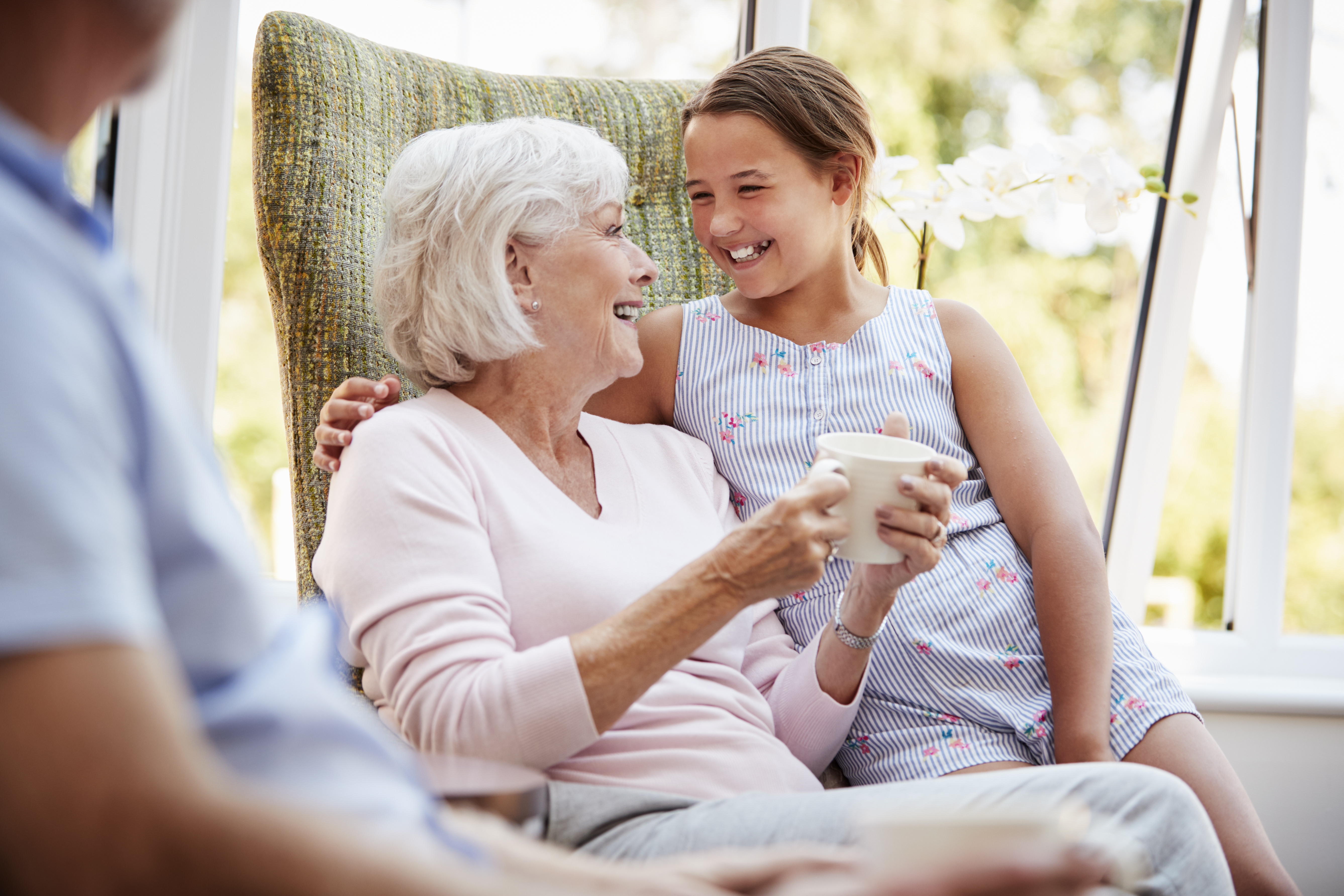 Granddaughter Visiting Grandparents In Lounge Of Retirement Home