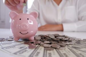 people inserting coin in Piggybank with coins and money over the