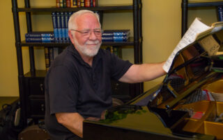 smiling Buena Vida resident playing piano