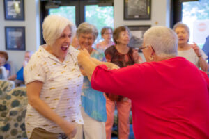 residents and staff laughing and dancing together