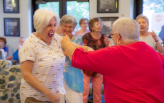 residents and staff laughing and dancing together