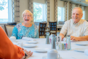 CCRC residents laughing at dinner table