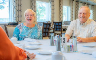 CCRC residents laughing at dinner table