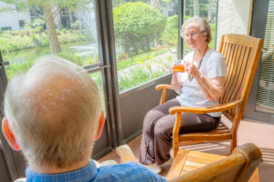 smiling residents sitting on patio drinking tea